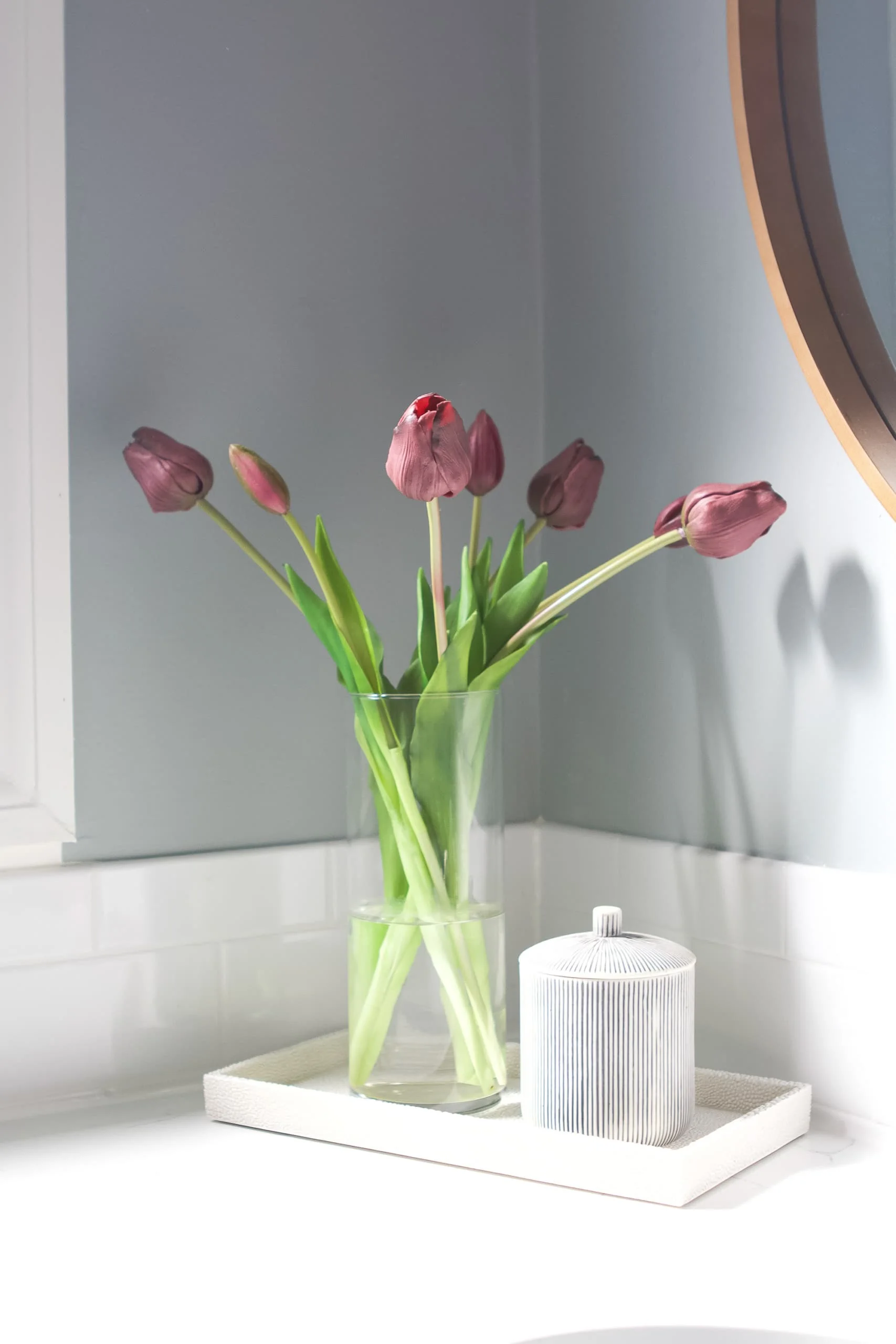 Faux tulips in a tray on top of a bathroom counter